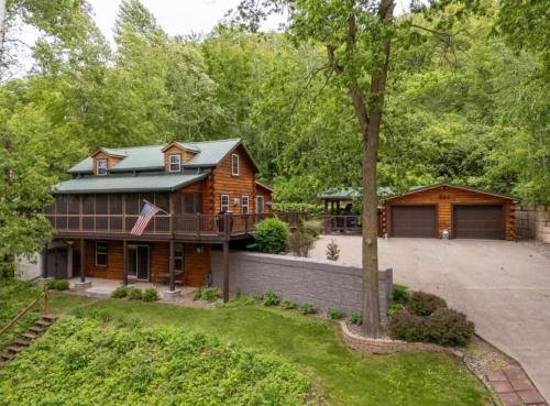 a log home with a porch and a garage at The Cozy Family Wabasha Cabin in Wabasha