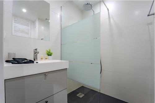 a white bathroom with a sink and a shower at Ski in-out, Heart Val Thorens, Charming Studio, Wifi in Val Thorens