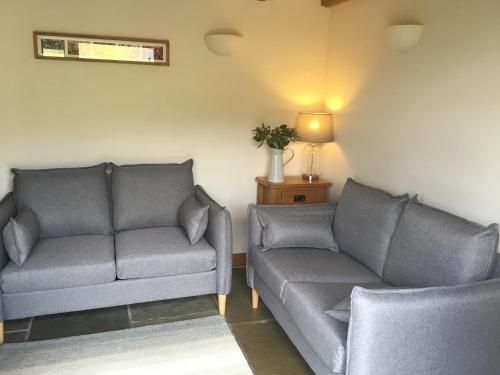 ein Wohnzimmer mit zwei Sofas und einer Couch in der Unterkunft Crabapple Cottage in Llanyblodwel