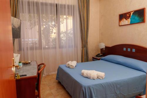 ein Schlafzimmer mit einem Bett und einem Tisch mit Handtüchern darauf in der Unterkunft B E B Hotel Alexia in Catanzaro