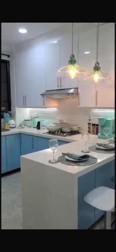 une cuisine avec des placards bleus et un comptoir blanc dans l'établissement Las Torres, à Sucúa