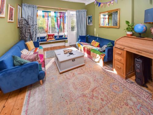a living room with blue couches and a fireplace at Sunnycote in Arnside