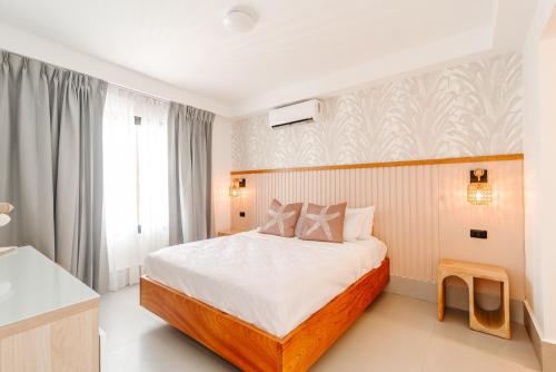 a hotel room with a bed and a window at Prado Suites Las Terrenas in Las Terrenas