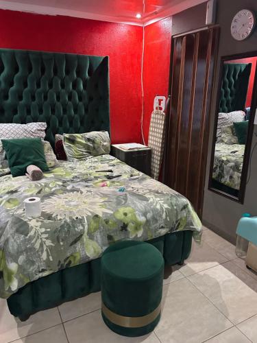 een slaapkamer met een groot bed en een rode muur bij Lake boutique hotel empire in Thohoyandou