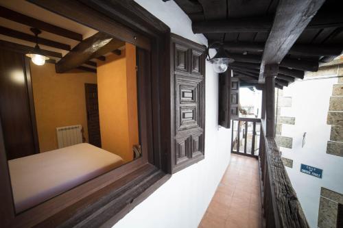 een raam in een kamer met een bed erin bij Casa Rural LA REGADERA I in Candelario