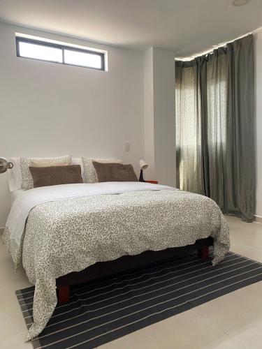 a white bedroom with a large bed and a window at Candilejas in Fredonia