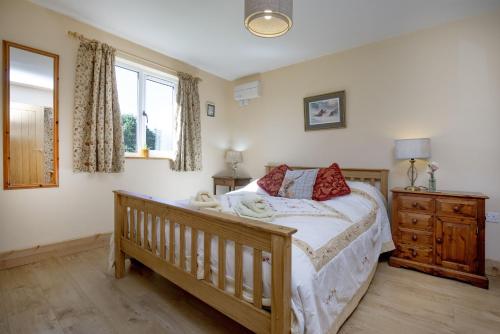 StogumberにあるWatermead Lodgeのベッドルーム1室(ベッド1台、木製ドレッサー付)