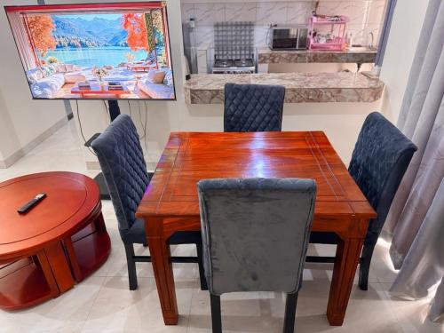a dining room with a wooden table and chairs at CHS Vacation Stays Limited in Kampala