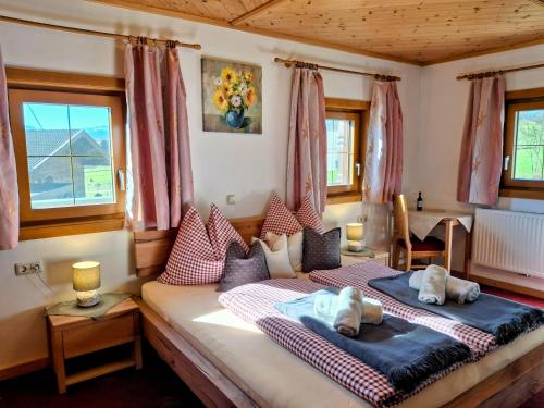 a bedroom with two beds and two windows at Lampererhof in Sankt Johann in Tirol