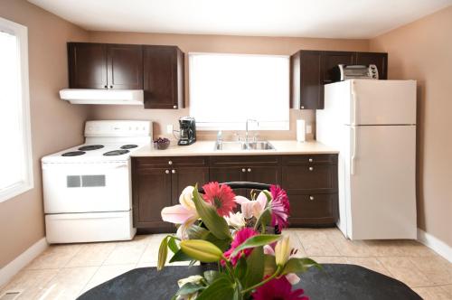 a kitchen with a white refrigerator and a table with flowers at Misty Retreat in Niagara Falls