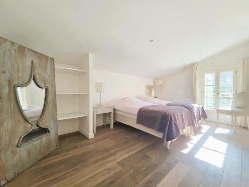 ein Schlafzimmer mit einem Bett und einem Spiegel an der Wand in der Unterkunft HORIZON grande maison de charme à La Couarde in La Couarde-sur-Mer