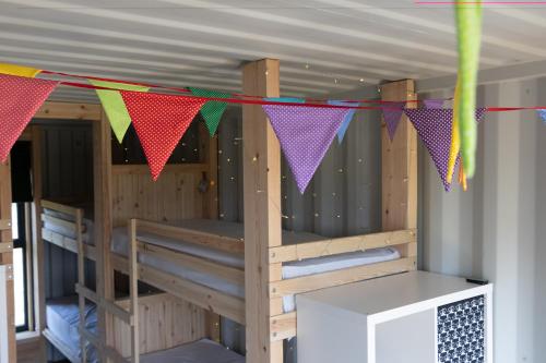a room with bunk beds with colorful flags at 11 Bee Hive, Camp Tapnell in Yarmouth