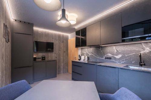 ゼルデンにあるApart Reinstadlerのキッチン(青いキャビネット、白いテーブル付)