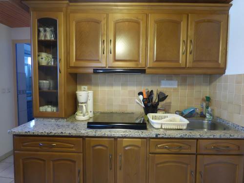 een keuken met houten kasten en een spoelbak bij Gite Chez Balum - 1 proche Lourdes in Lézignan