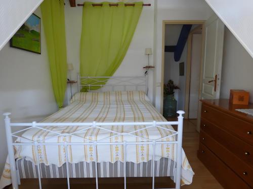 een slaapkamer met een wit bed en groene gordijnen bij Gite Chez Balum - 2 Proche Lourdes in Lézignan