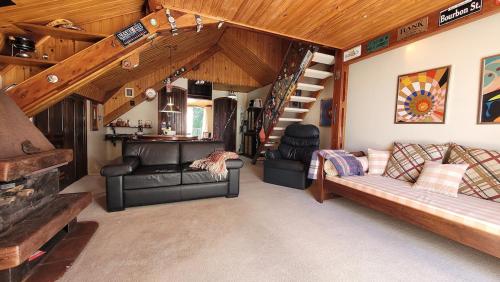 ein Wohnzimmer mit einer Couch und einer Treppe in der Unterkunft Tranquility and Nature - 8 minutes from downtown Capivari in Campos do Jordão