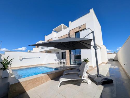 a villa with a swimming pool and an umbrella at R-40-E Esplendor in Los Montesinos