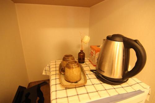 a tea kettle and a container on a table at Sungsim Hanok Guesthouse in Jeonju