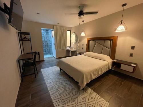 a bedroom with a bed and a table and a mirror at Hotel Casa María Tamasopo in Tamasopo