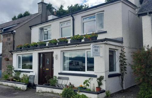 a house with potted plants on top of it at Clisham Bed and Breakfast in Lochcarron