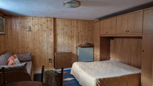 a bedroom with a bed and a couch at Appartamento vicino a Bormio in Valdisotto