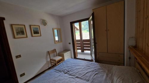 a bedroom with a bed and a door to a balcony at Appartamento vicino a Bormio in Valdisotto