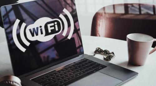 a laptop computer sitting on top of a table with a cup at UIM Mediterraneo Poeta 4 Wifi in Puerto de Sagunto