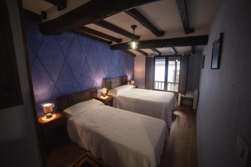 ein Schlafzimmer mit zwei Betten und einem Fenster in der Unterkunft Casa Rural LA REGADERA II in Candelario