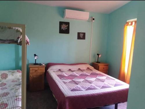 1 dormitorio con 1 cama, 2 vestidores y espejo en Departamentos Susana & Aldo, en Valle Hermoso