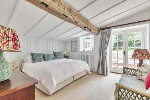 a bedroom with a bed and a large window at The Long Cottage with attic in Flitcham