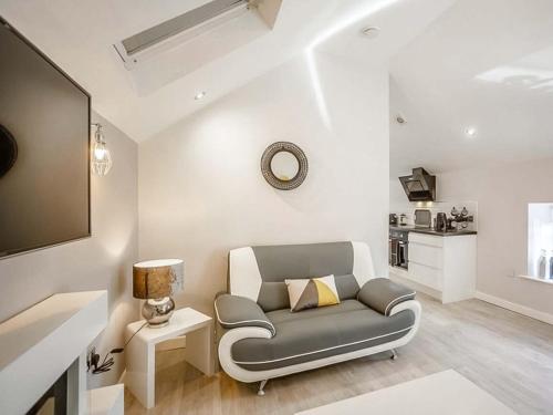 ein Wohnzimmer mit einer grauen Couch und einem Tisch in der Unterkunft Swallow Cottage-Ukc6983 in Castleside