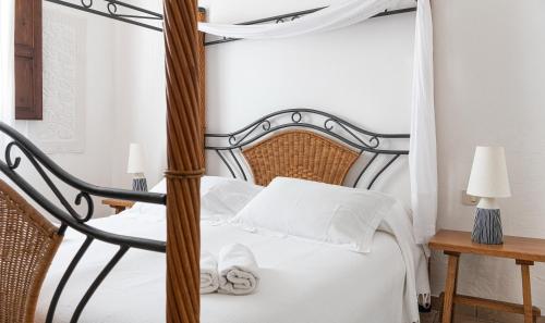 a bedroom with a black and white canopy bed at Villa Fiori 4 in Is Molas 