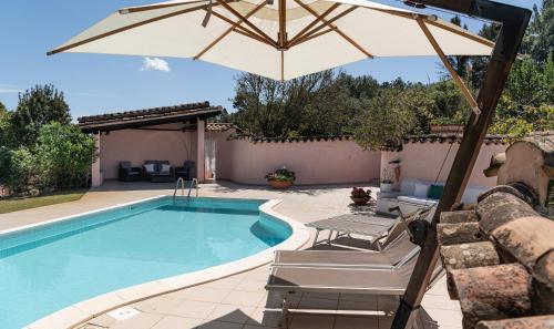 a swimming pool with an umbrella and chairs and a table and sidx sidx at Villa Fiori 4 in Is Molas 