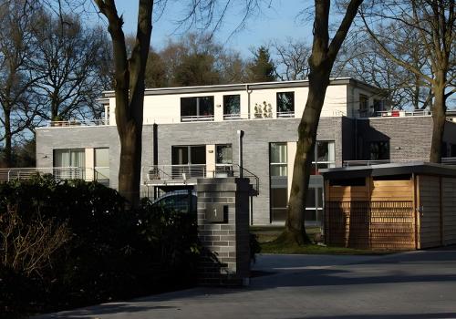 a large white building with trees in front of it at Moderne Ferienwohnung 2 Pers in Bad Zwischenahn