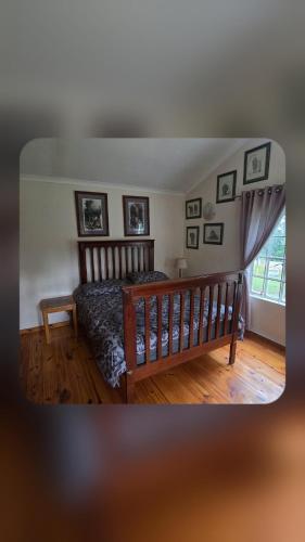a bedroom with a bed and pictures on the wall at Bunkers Accomodation in Underberg