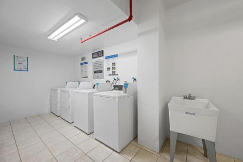 a bathroom with a row of washing machines and sinks at Ocean Reserve 1524 in Miami Beach