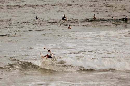 een man die op een surfplank in de oceaan op een golf rijdt bij Surfside El Tunco in Tamanique