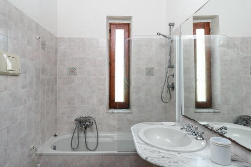 a bathroom with a sink and a tub and a shower at Villa Roberta in Monte Nai