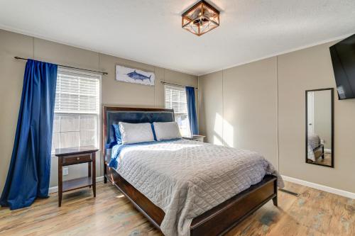 une chambre avec un lit et une fenêtre avec des rideaux bleus dans l'établissement Coastal Cozy - Newport Home with Private Hot Tub, à Broad Creek