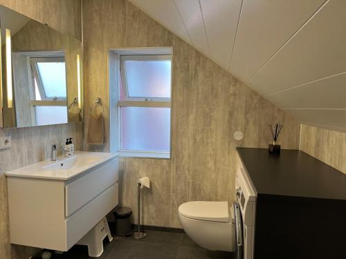 a bathroom with a sink and a toilet at Guesthouse Hvammur by the Harbour in Höfn