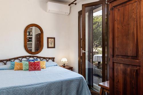 een slaapkamer met een bed, een spiegel en een raam bij Villa Palme in Monte Nai