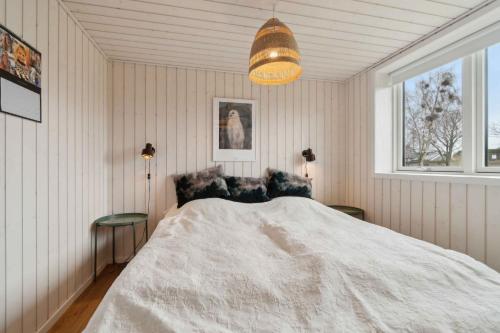 a bedroom with a large bed and a window at Snug In Snogebæk A Modern Cozy Summer House in Neksø