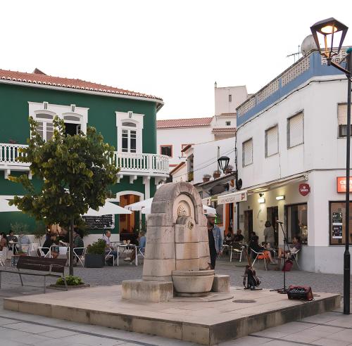 a statue in the middle of a street with buildings at Casa Das Batatas in Odeceixe