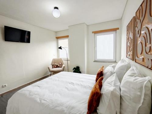 a bedroom with a large white bed and a chair at Douro Valley Private Terrace & Lounge in Armamar