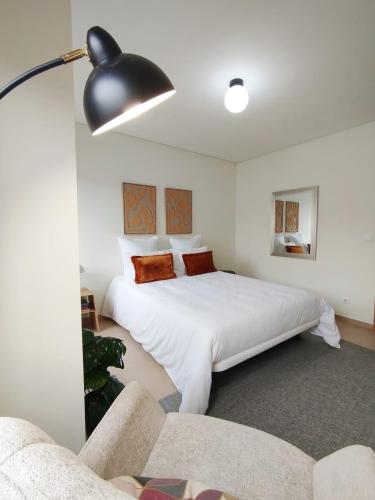 a bedroom with a large white bed and a couch at Douro Valley Private Terrace & Lounge in Armamar