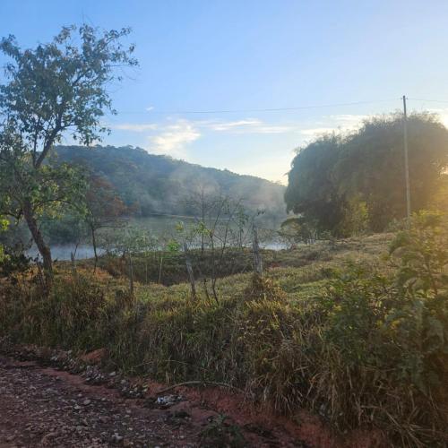 a view of a river from a field with trees at Sitio Encanto in João Ribeiro