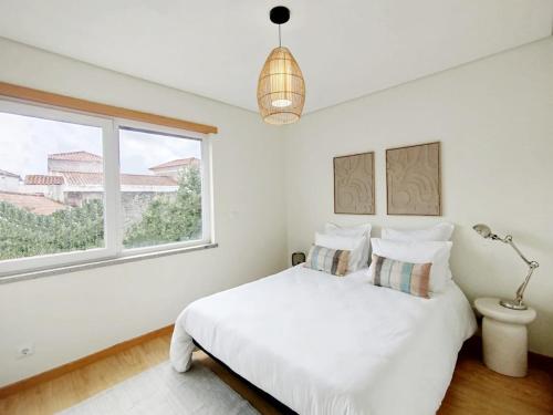 ein weißes Schlafzimmer mit einem Bett und einem Fenster in der Unterkunft Douro Valley Private Terrace & Lounge in Armamar