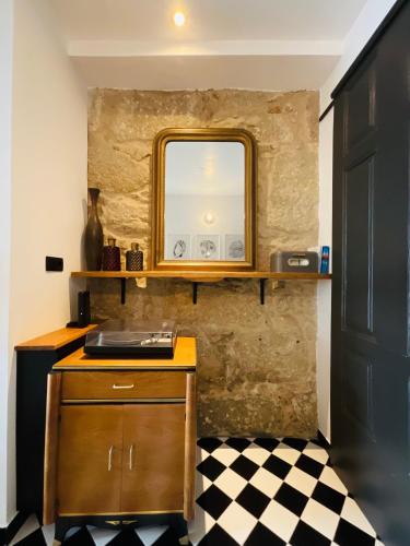 a bathroom with a sink and a mirror and a checkered floor at Boreal Porto Gaia - Patio & Pool in Vila Nova de Gaia