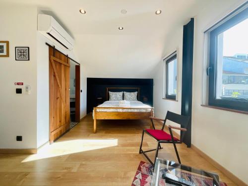 een slaapkamer met een bed, een stoel en een raam bij Boreal Porto Gaia - Patio & Pool in Vila Nova de Gaia