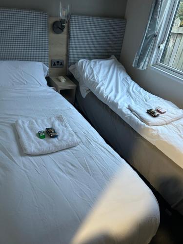 1 Schlafzimmer mit 2 Betten, Handtüchern und einem Fenster in der Unterkunft Haven Blackpool Fleetwood holiday park in Fleetwood
